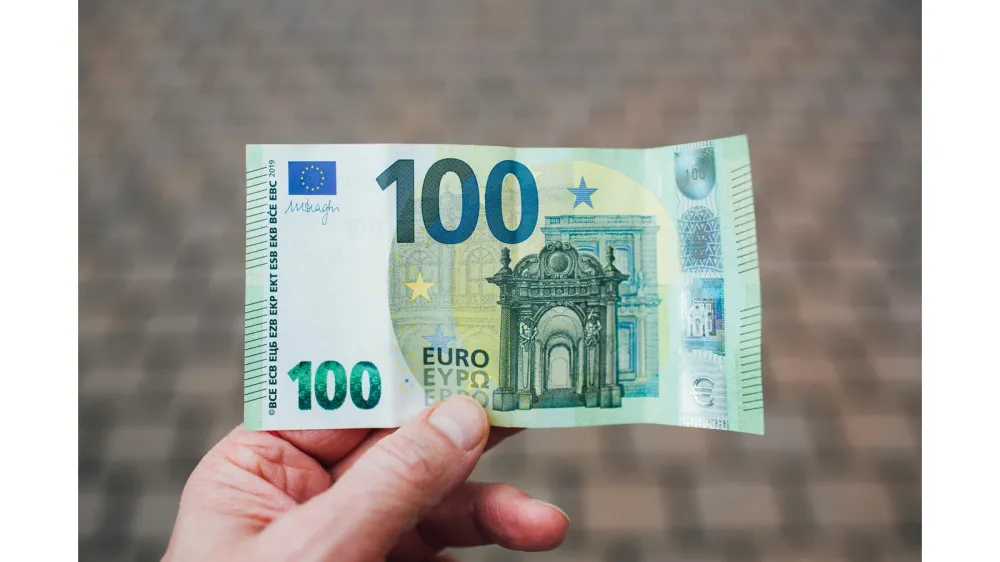 Billet de 100 euros dans une main