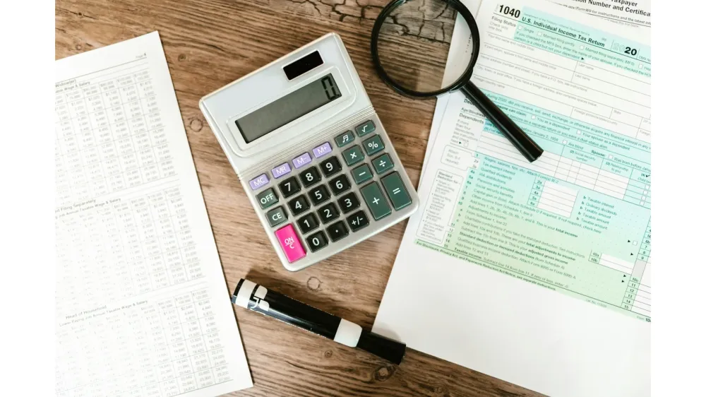 Feuille déclaration d'impôts avec une calculatrice et une loupe