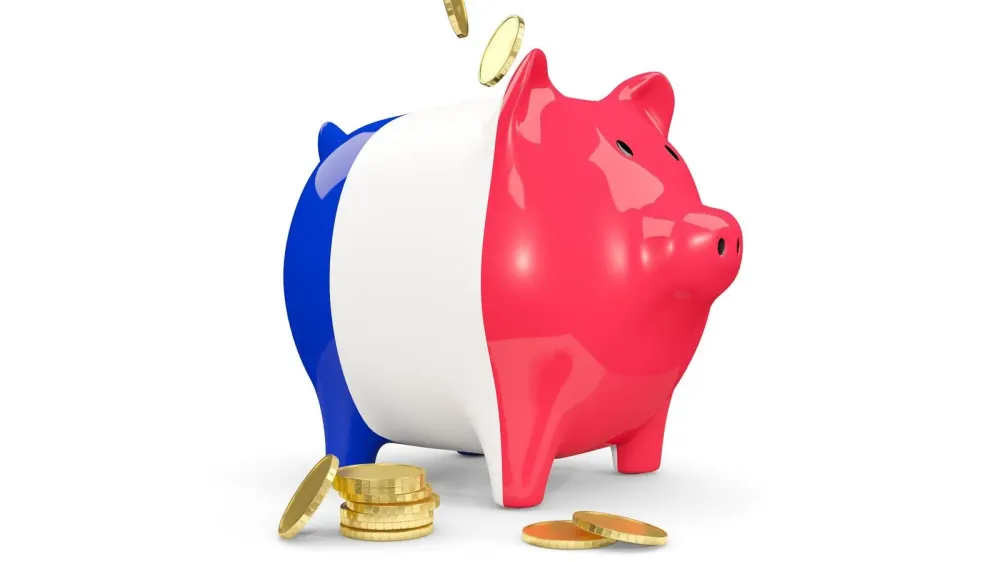 Tirelire aux couleurs du drapeau français avec des pièces d'or, symbolisant l'épargne et les dividendes.
