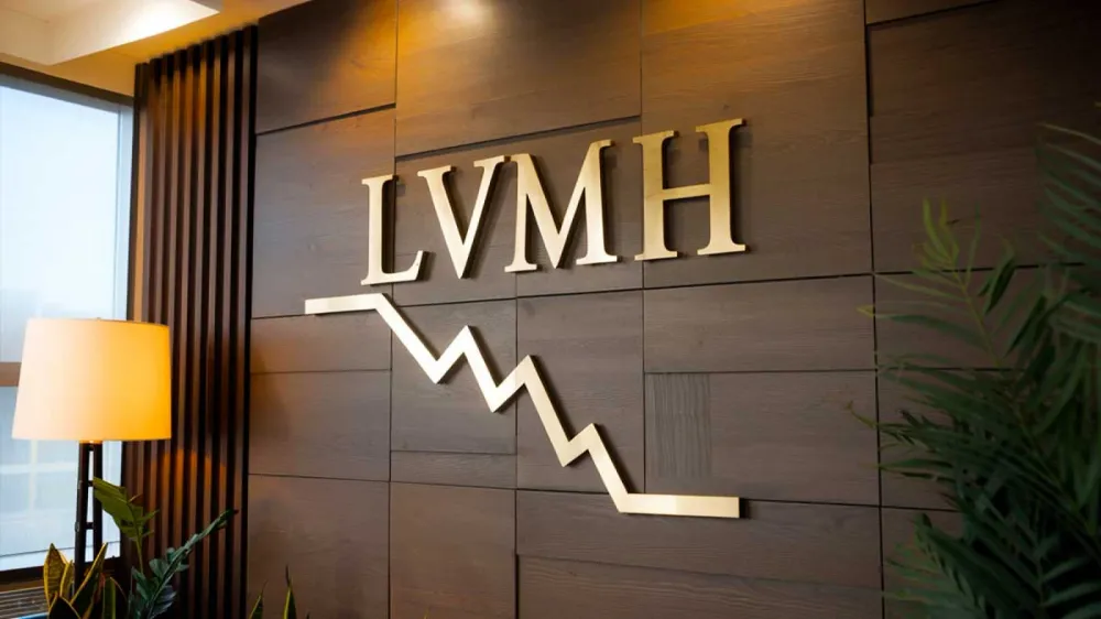 Logo LVMH avec un graphique boursier descendant, symbolisant une année difficile pour le luxe français.