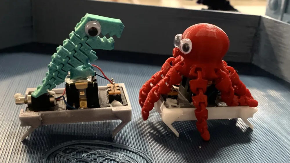 Un dinosaure et une pieuvre robotiques, imprimés en 3D, avec des yeux globuleux, symbolisant l'innovation dans le marché du jouet.
