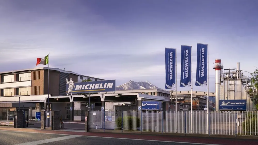 Usine Michelin avec le drapeau italien et des bannières Michelin flottant au vent.