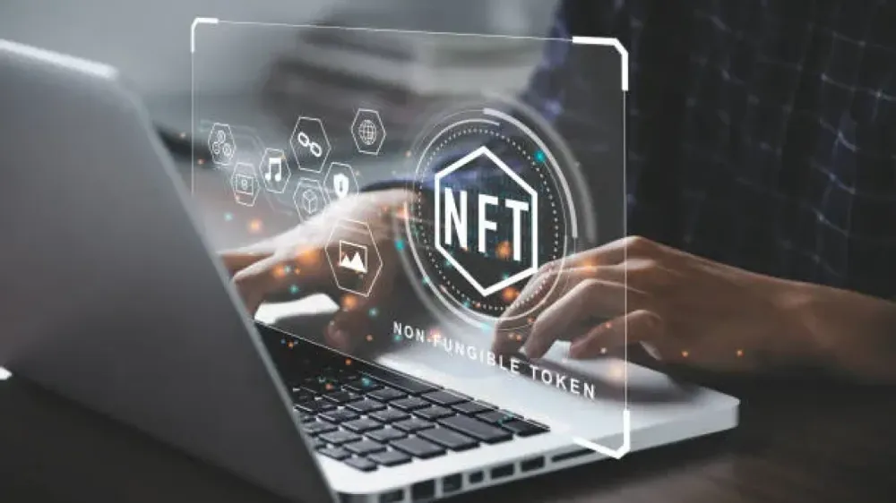 Un homme travaille sur un ordinateur portable avec un overlay NFT, symbolisant l'utilisation des NFTs en entreprise.