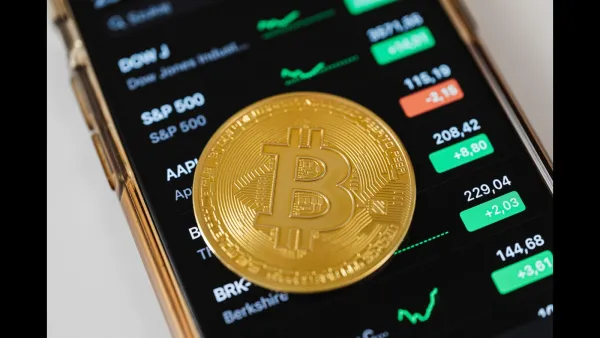 Pièce de Bitcoin sur un téléphone avec des cours de bourse
