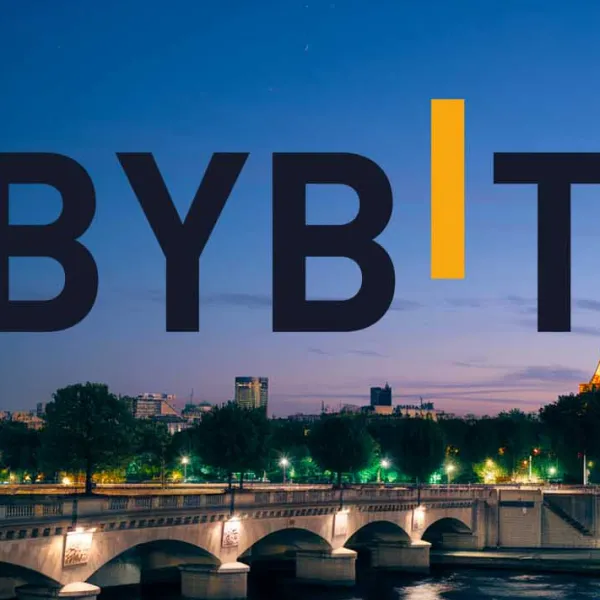 Le logo Bybit superposé à une vue nocturne de Paris avec un pont illuminé et la Tour Eiffel en arrière-plan.