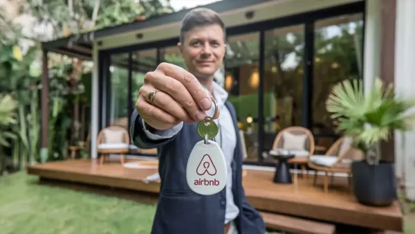 Un homme souriant tenant une clé Airbnb devant une maison moderne, symbolisant l'impact des nouvelles lois sur les locations de courte durée.