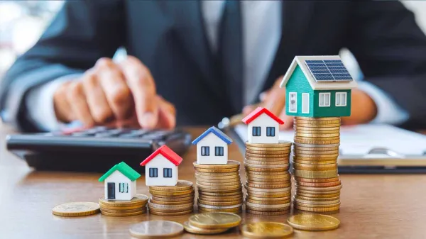 Illustration de l'investissement immobilier et son rendement, avec des maisons miniatures sur des piles de pièces, symbolisant la croissance financière.