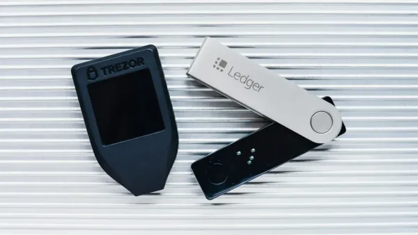 Portefeuilles physiques Trezor et Ledger pour stocker des cryptomonnaies hors ligne, offrant une sécurité accrue contre le piratage.